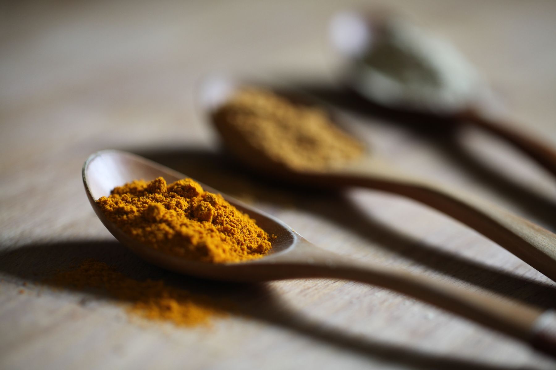 Turmeric powder on a wooden spoon